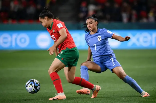 A Morocco player runs past a French player on the wing.