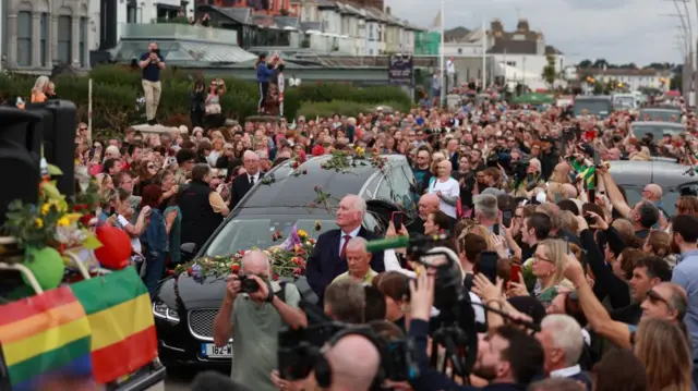 a car drives through a crowd