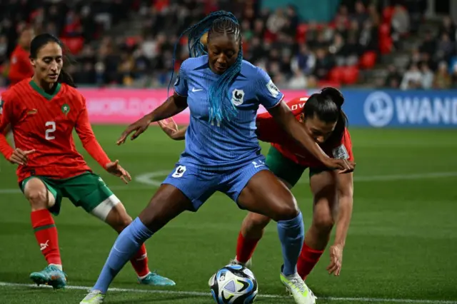 Diani holds off challenges from two Morocco defenders.