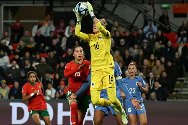 Peyraud-Magning comes to claim a cross in the box among defenders and attackers.