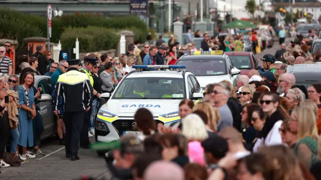 Fans and Gardai (Irish police) outside O'Connor's home in Bray, County Wicklow, ahead of the cortege
