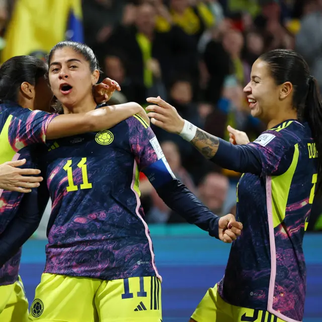 Usme pumps her fists as she celebrates with teammates.