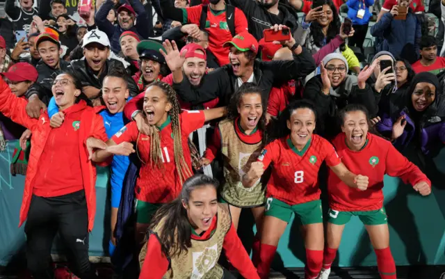 Morocco players celebrate by taking pictures with their fans.