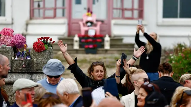 A woman raises her hands above her head