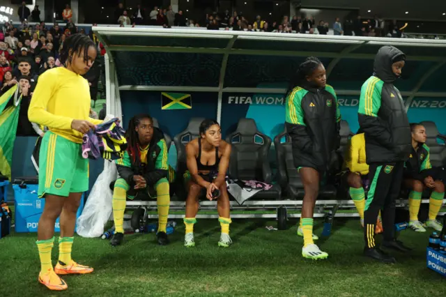 Jamaica players sit desconsolate on the bench at full time.