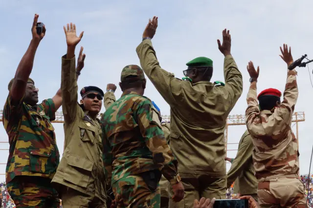 Mohamed Toumba (second from right) and other junta members hail coup supporters at a stadium in Niamey on Sunday.
