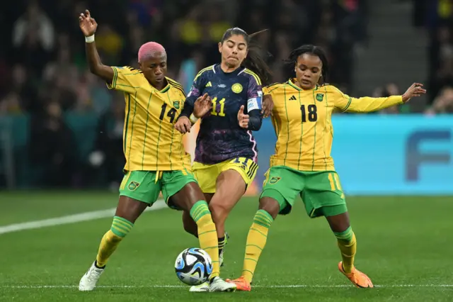 Two Jamaica defenders close down Colombia's captain.