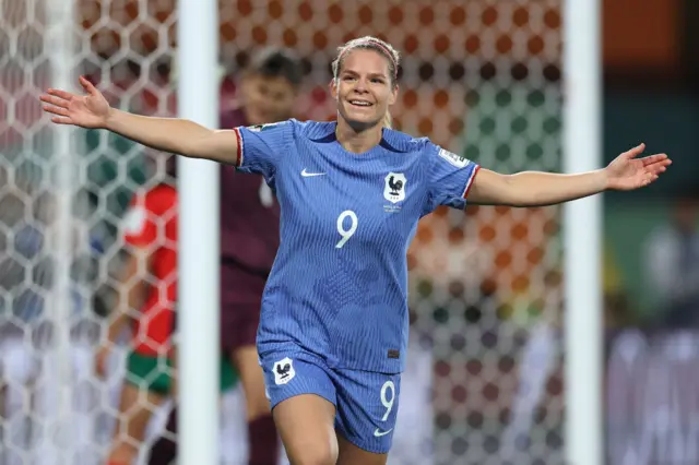 Le Sommer holds her hands out wide to celebrate her second goal.