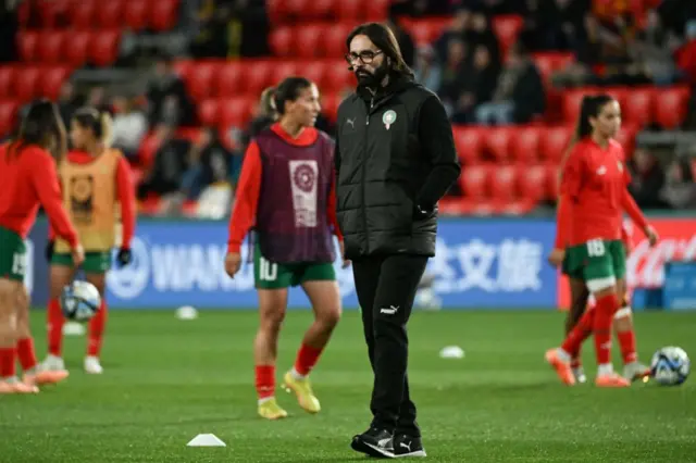 Morocco boss Reynald Pedros looks on as the sides warm up, with his hands in his pockets.