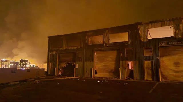 A burning building amid orange smoke