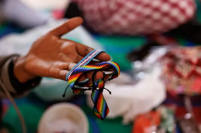 A woman identifying as a lesbian makes jewellery to sell whilst at a shelter for lesbian, bisexual, and queer women on April 24, 2023 in Kampala, Uganda.