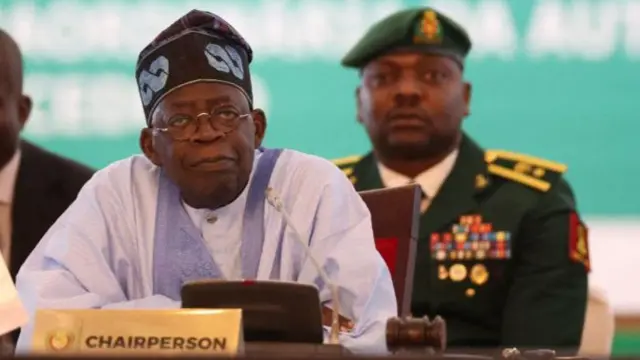 Chairperson of Economic Community of West African States (ECOWAS) and President of Nigeria, Bola Ahmed Tinubu, reacts while addressing the ECOWAS head of states and government in Abuja on July 30, 2023.