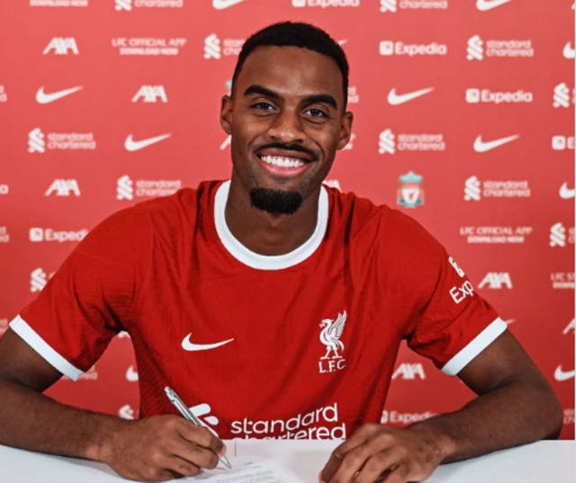 Ryan Gravenberch in a Liverpool shirt signing for the club