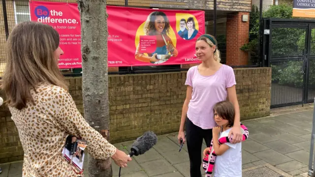 Helena Wilkinson outside Corpus Christi Catholic school in Brixton, speaking with a parent and child