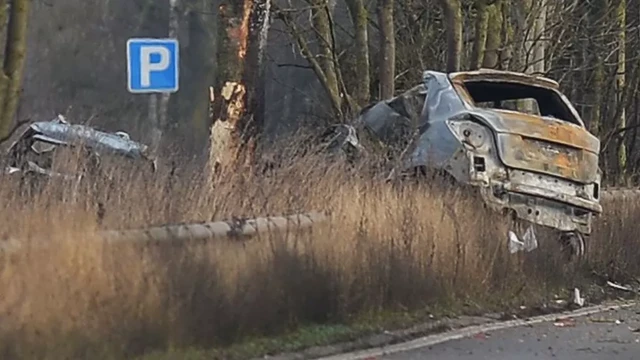 A burned out Skoda, split in two across an barrier on the side of the A46