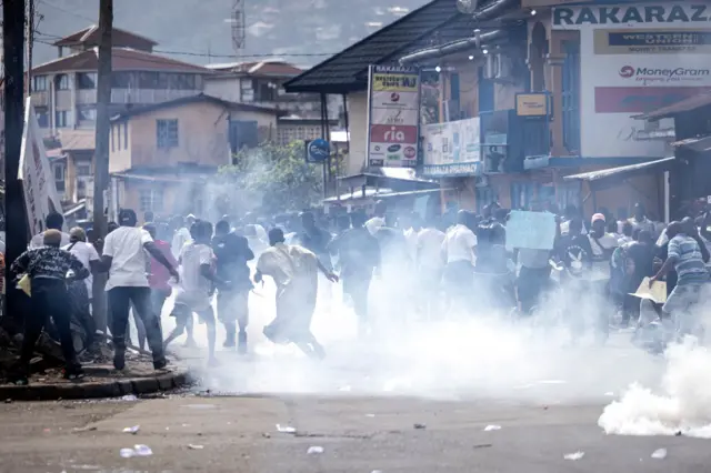 Supporters of the opposition party, All People's Congress (APC), run from teargas during a protest calling for the Chief electoral Commissioner, Mohamed Konneh, to step down after allegations of electoral fraud in Freetown on June 21, 2023.