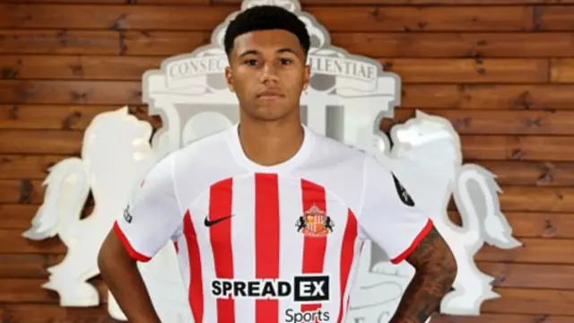 Mason Burstow poses in a Sunderland kit