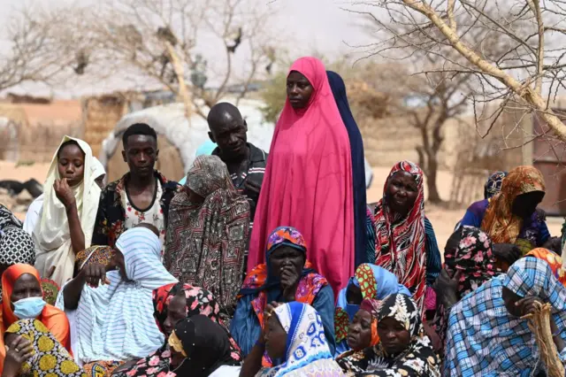 People gather as United Nations (UN) Secretary-General Antonio Guterres (not seen) visits an internally displaced persons (IDP) camp in Ouallam, Niger