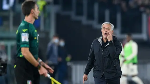 Jose Mourinho points to his eye while looking at the linesman