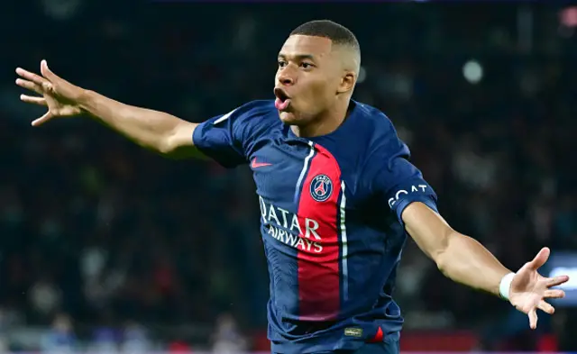 Kylian Mbappe with his arms aloft celebrating