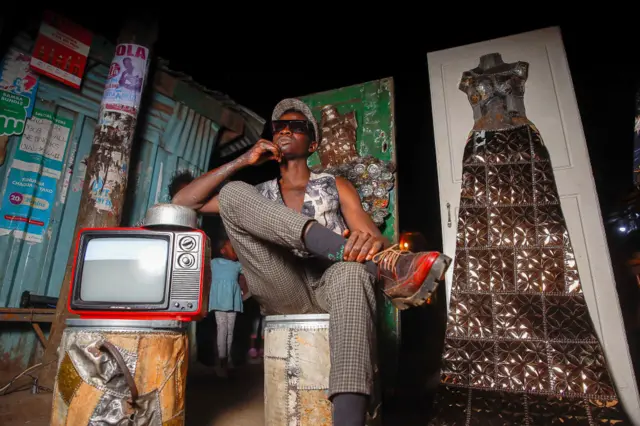 Man posing with sculptures in Kenya