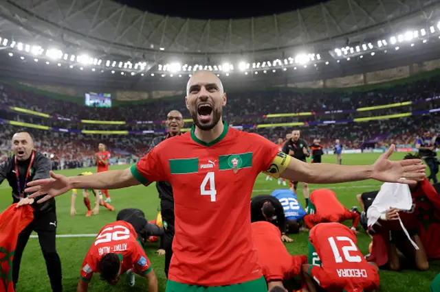 Sofyan Amrabat with his arms aloft celebrating in the World Cup whilst playing for Morocco