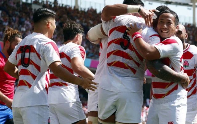 Japan's Amato Fakatava celebrates scoring their first try with teammates