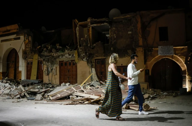 People pass a fallen-in building in the old quarter in Marrakesh on 10/9