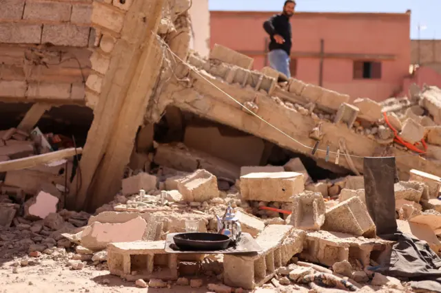 A tea set placed atop rubble of a building in Amizmiz