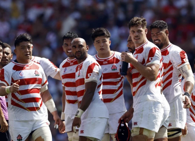 Japan team crowd together before half-time