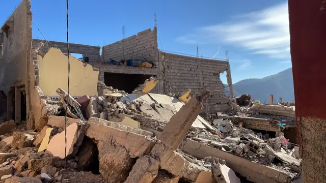 A pile of rubble in the middle of three brick walls