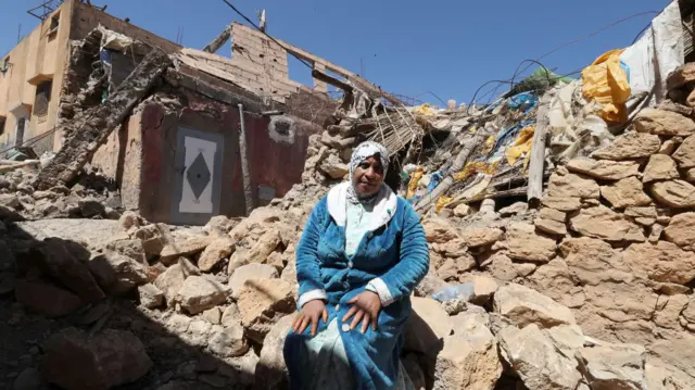 A woman sat in rubble