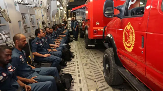 Search and rescue personnel and vehicles inside plane