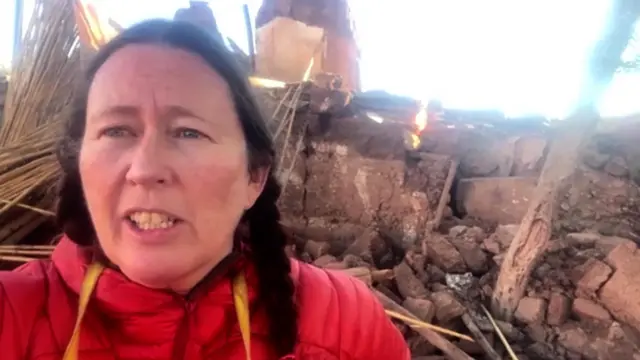 Alice Morrison speaking with rubble behind