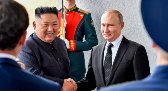 Kim Jong Un and Vladimir Putin shake hands in 2019