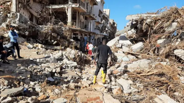 Members of Libyan Red Crescent work in an area affected by flooding in Derna, Libya in this social media image released 12 September 2023