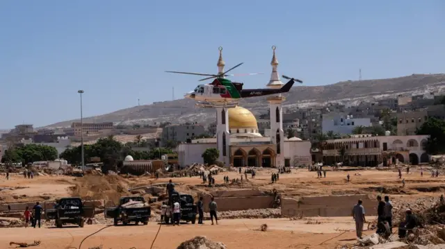 Helicopter flies in front of a damaged mosque in Derna, Libya - 13 September 2023