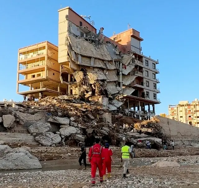 Emergency members work near a damaged building after a powerful storm and heavy rainfall hit Libya, in Derna, Libya, September 12, 2023