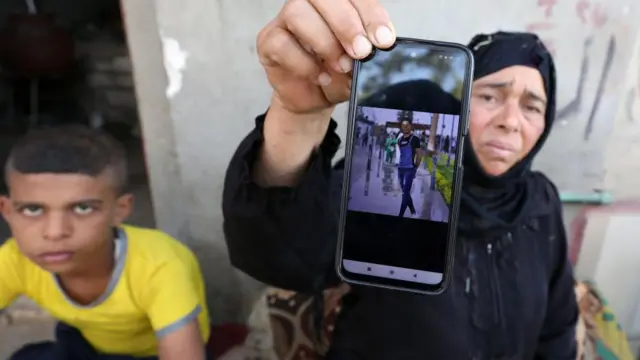 A relative of one of the Egyptian victims who died in Derna hold us a phone with his photo - shows his picture in Kafr Sharif village in Beni Suef province, Egypt - 13 September 202