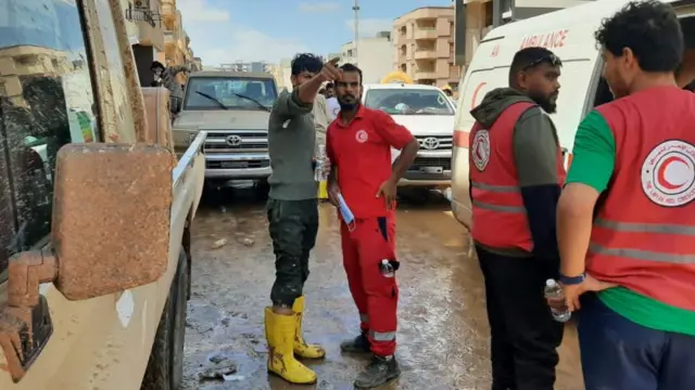 Members of Libyan Red Crescent work in an area affected by flooding in Derna, Libya