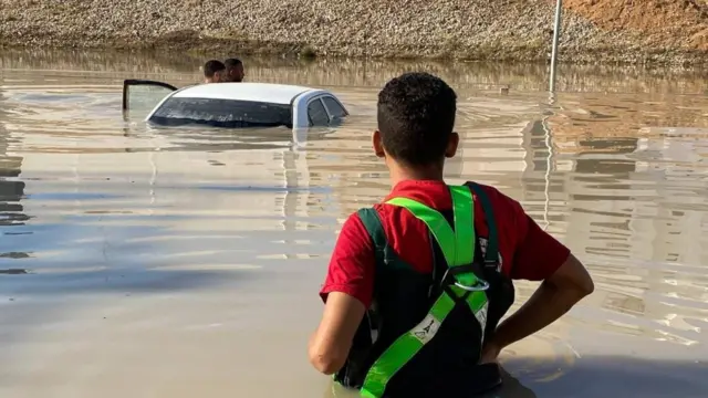 A handout photo made available by the Libyan Red Crescent shows members of the organization inspecting vehicles in the floods at an undefined location in eastern Libya, 11 September 2023 (issued 13 September 2023)