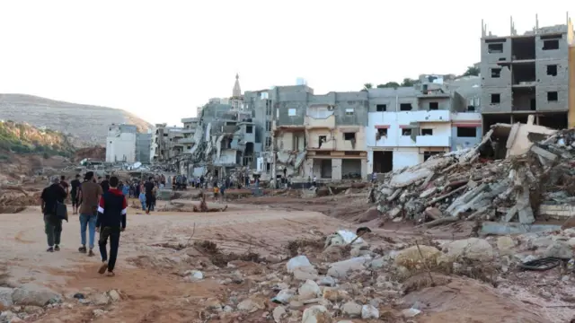 People walk amongst debris