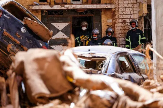 Members of the rescue team from the Egyptian army look at the damaged cars,