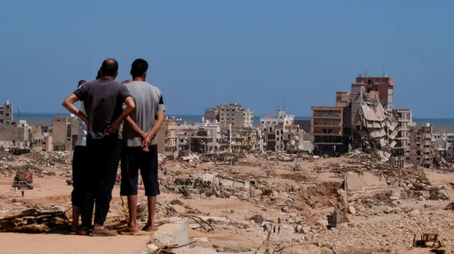 A view shows people looking at the damaged areas, in the aftermath of the floods in Derna,