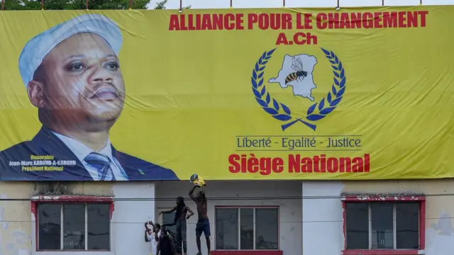 Police officers stand guard as supporters of Jean-Marc Kabund, demonstrate for his release, at the national headquarters of the Alliance for Change party in Limete, Kinshasa, on March 15, 2023 - The former leader of the presidential party in the Democratic Republic of Congo, who switched to the opposition, was arrested in August 2022 as part of a prosecution for contempt of the head of state