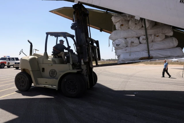 A worker unloads medical supplies and relief items off a cargo aircraft sent from the UAE in Benghazi - 15 September 2023