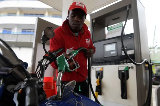 A worker fills the tank of a motorcycle at a petrol station as Kenya's government announced a new increase in fuel prices, Nairobi on May 17, 2023.