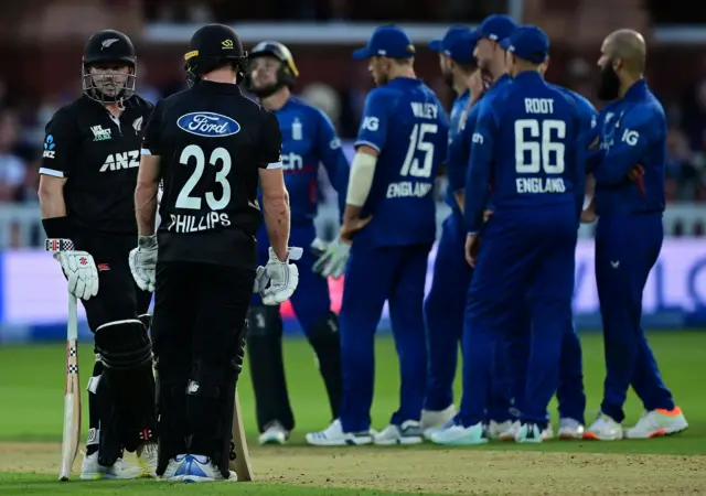 England and New Zealand's Glenn Phillips and Henry Nicholls watch on during a review