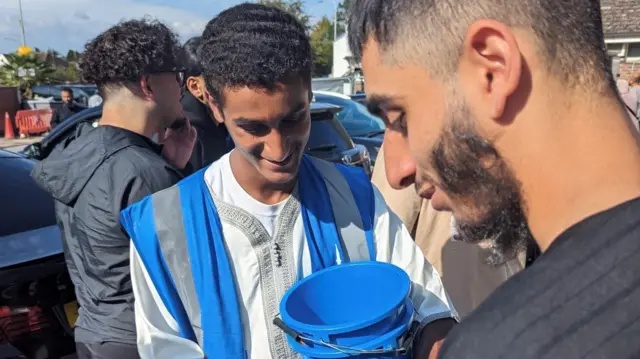 Islamic Relief charity worker collecting donations outside a mosque