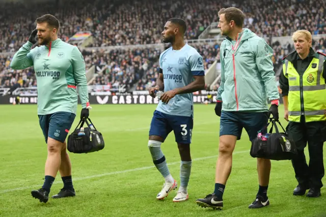 Rico Henry of Brentford walks off the pitch due to injury